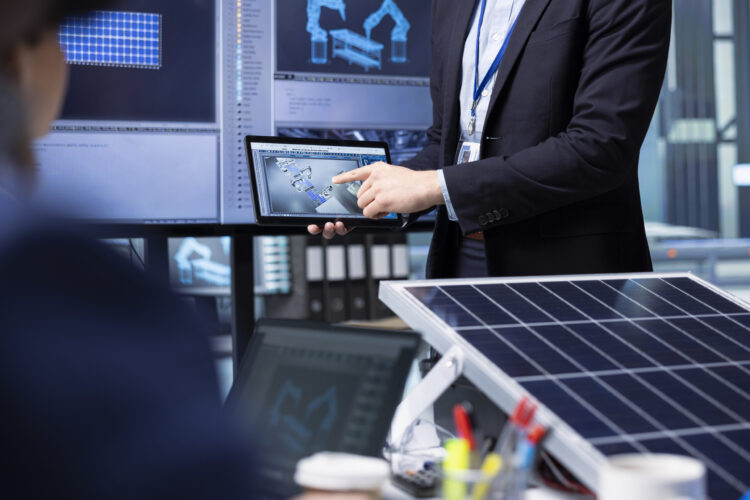 Investors examine solar panel surface using tablet, discussing design efficiency